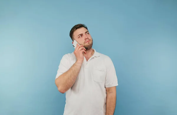 Hombre Adulto Con Cerdas Habla Por Teléfono Sobre Fondo Azul — Foto de Stock