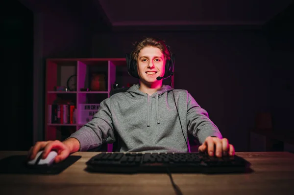 Θετικός Νεαρός Άνδρας Ακουστικά Κάθεται Στο Σπίτι Στον Υπολογιστή Και — Φωτογραφία Αρχείου