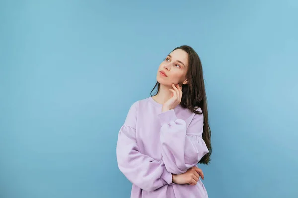 Menina Bonita Uma Camisola Fica Fundo Azul Olha Para Longe — Fotografia de Stock