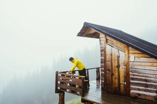 Homem Casaco Amarelo Fica Terraço Uma Casa Campo Nas Montanhas — Fotografia de Stock
