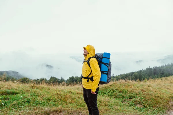 Turista Masculino Positivo Uma Jaqueta Amarela Com Uma Mochila Fica — Fotografia de Stock