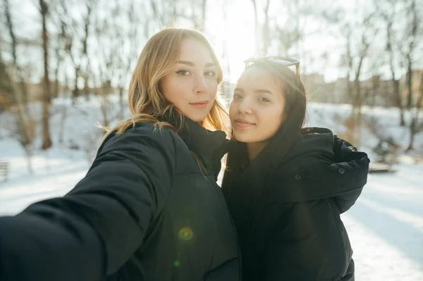 Beautiful Two Girlfriends Take Selfie Winter While Walking Park Looking — Foto Stock