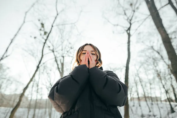 Žena Zahřívá Ruce Tím Dýchá Zasněženém Pozadí Během Zimní Procházky — Stock fotografie