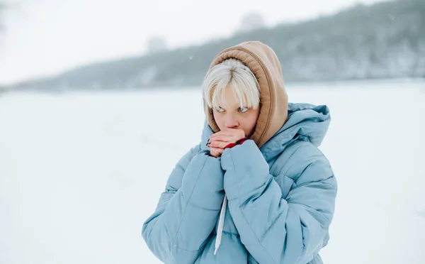 Dziewczyna Blond Włosami Ciepłych Ubraniach Rozgrzewa Się Oddychając Rękach Zimowym — Zdjęcie stockowe