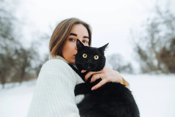 Piękna Kobieta Stojąca Zimą Ulicy Ramionach Czarnym Kotem Patrząca Kamerę — Zdjęcie stockowe