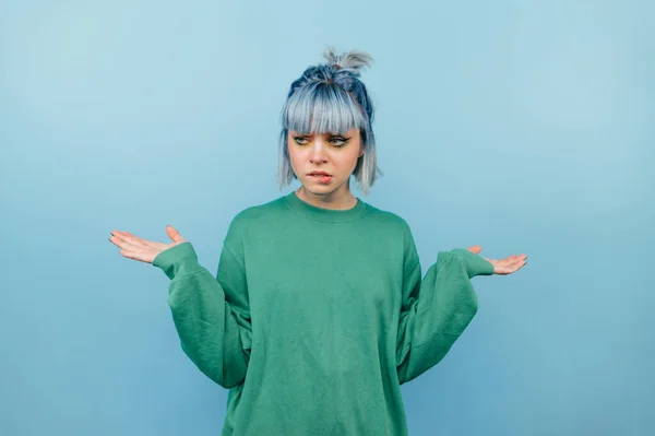 Confused Teen Girl Blue Hair Green Sweatshirt Stands Blue Background — Stock Photo, Image