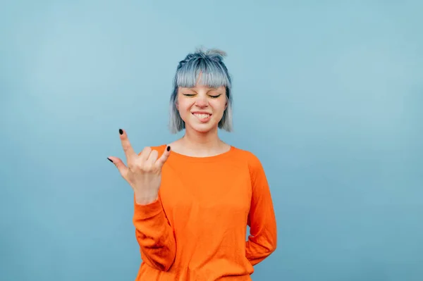 Chica Positiva Una Sudadera Naranja Levanta Sobre Fondo Azul Con — Foto de Stock