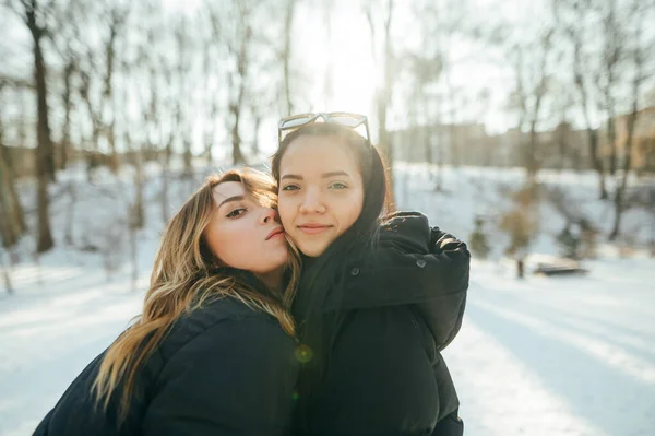 Beautiful Young Girlfriends Warm Clothes Hugging Snowy Park Posing Camera — Fotografia de Stock