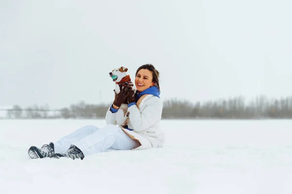Счастливая Дама Теплой Куртке Сидит Снегу Озере Маленькой Собачкой Руках — стоковое фото