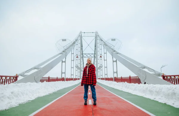 Hipster Girl Red Shirt Jeans Winter Walk Stands Snowy Bridge — Zdjęcie stockowe