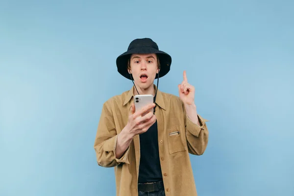 Surprised Young Hipster Man Stands Smarton Hands Blue Background Looks — Foto Stock