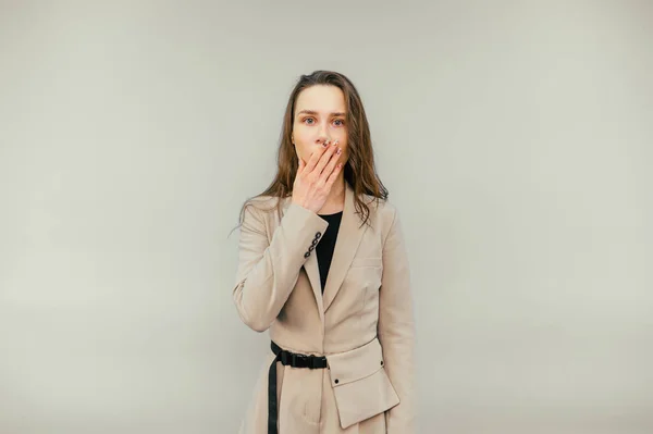 Shocked Woman Suit Stands Beige Background Covers Her Face Her — стоковое фото