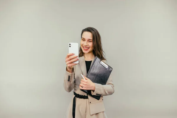 Beautiful Positive Woman Jacket Stands Beige Background Tablet His Hands — стоковое фото