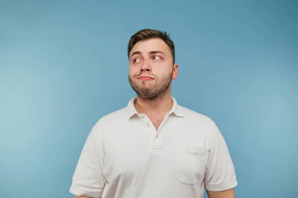 Cunning Man White Shirt Stands Blue Background Looks Away Sly — Foto de Stock