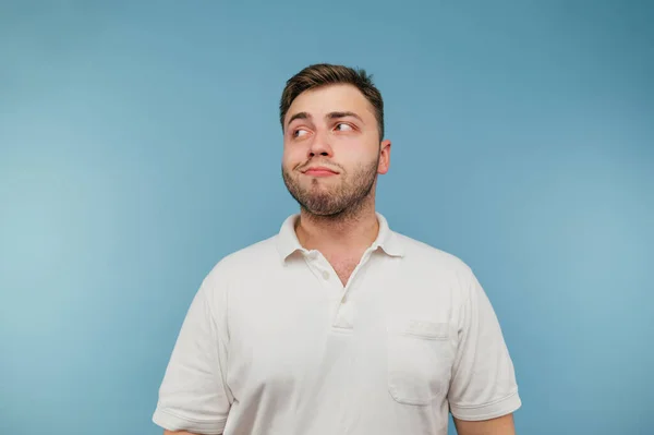 Listig Man Vit Shirt Står Blå Bakgrund Och Ser Bort — Stockfoto