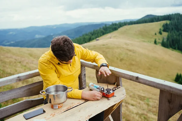 Man Sits Table Terrace House Mountains Prepares Eat Backdrop Mountain — стоковое фото