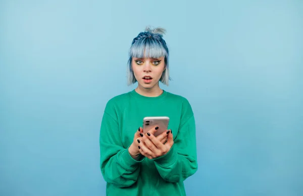 Surprised Hipster Girl Blue Hair Stands Blue Background Smartphone His — Fotografia de Stock