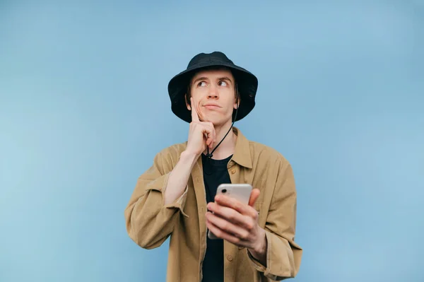 Pensive Young Man Panama Shirt Smartphone His Hand Stands Blue —  Fotos de Stock