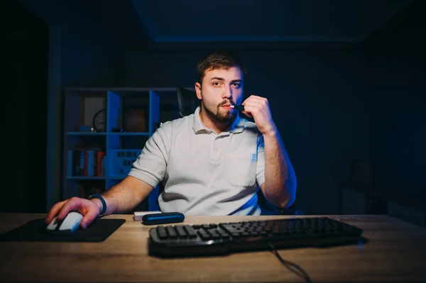 Concentrated Man Sitting Night Computer Smoking While Working Dark Room — Fotografia de Stock