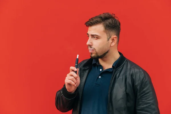 Adult Handsome Man Dark Clothes Stands Backdrop Red Wall Smokes — стоковое фото