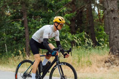 Profesyonel bisikletçi. Parkta spor aletleri ve şehir dışında antrenman yapıyor..