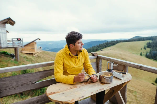 Homem Bonito Com Uma Jaqueta Amarela Come Nas Montanhas Terraço — Fotografia de Stock