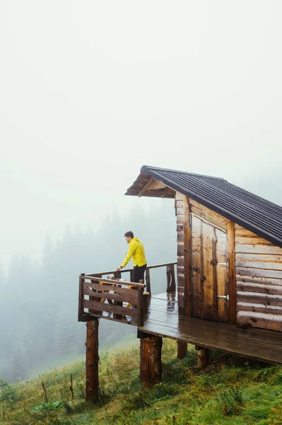Homem Com Uma Jaqueta Amarela Fica Terraço Uma Casa Montanha — Fotografia de Stock