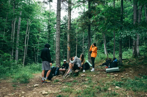 Group Young People Tourists Have Rest Sitting Forest Hike Talking — стоковое фото