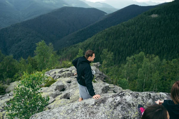 Male Tourist Casual Clothes Stands Rock Top Mountain Looks Away — Fotografia de Stock