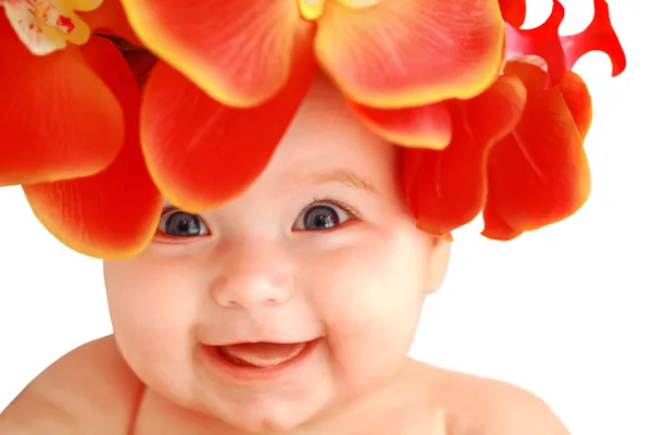 Lachendes glückliches kleines Mädchen mit Blumen Stockfoto