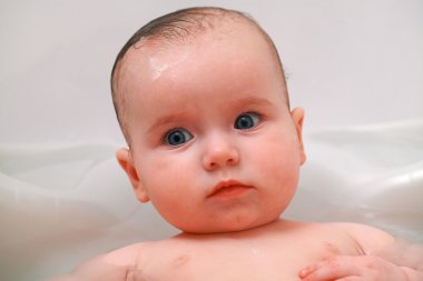 Cute baby girl having a bath clipart