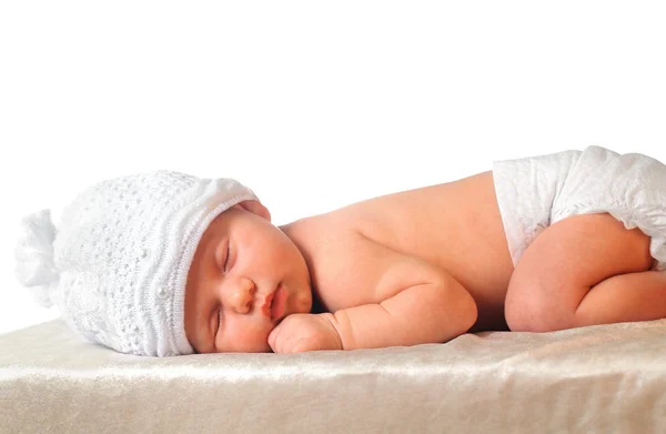 Спящая новорожденная девочка в белой шляпе в подгузнике — стоковое фото