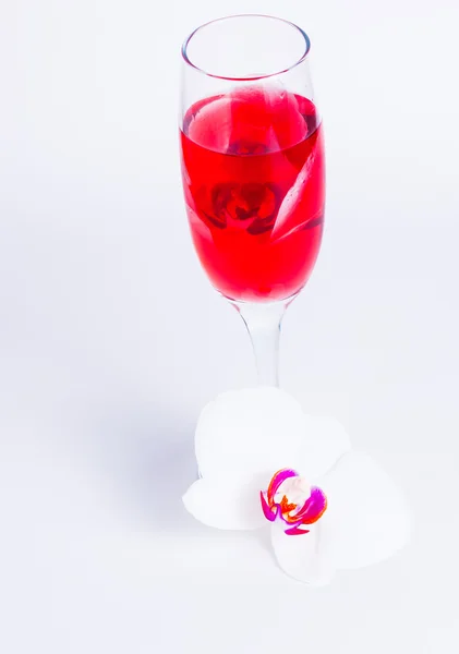 Стакан красного вина и орхидея — стоковое фото