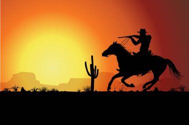 Silhouette cowboy riding a horse carrying a gun at sunset.
