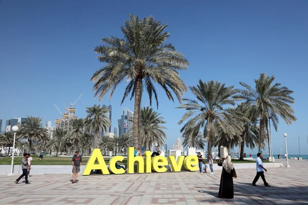 Slogan bereiken aan de kustweg van doha, qatar — Stockfoto