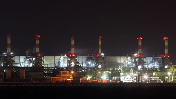 Нефтеперерабатывающий завод освещенный ночью — стоковое фото