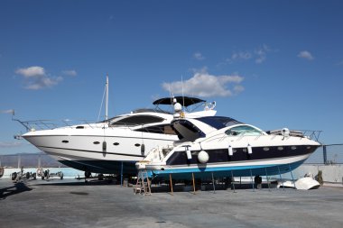 Motor yachts under maintenance in the drydock clipart