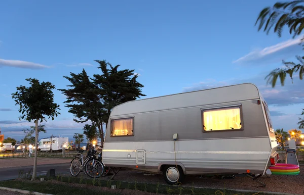 Caravana em um local de acampamento ao entardecer — Fotografia de Stock