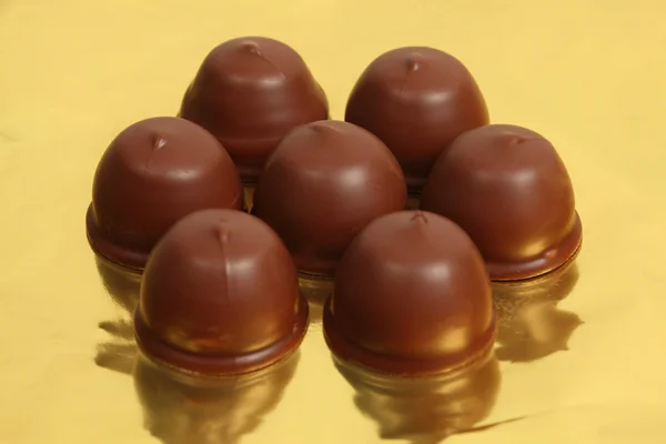 Chocolate truffles on golden foil — Stock Photo, Image