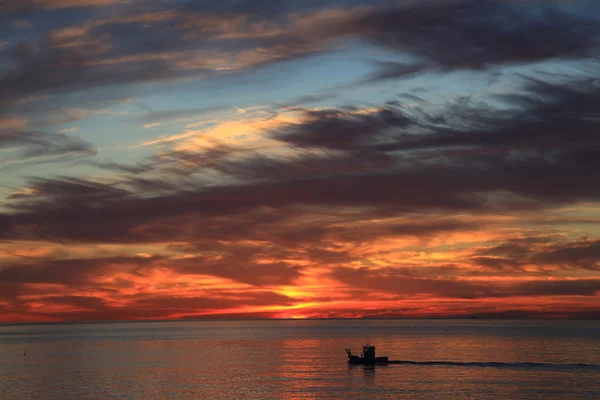 Barco de pesca no mar durante o nascer do sol — Fotografia de Stock