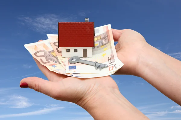 お金と空の背景を持つキーの家 — ストック写真