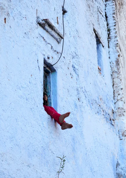 Παράθυρο με ένα παιδί που κάθεται σε αυτό. Chefchaouen, Μαρόκο — Φωτογραφία Αρχείου