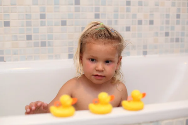 Little girl playing with rubber ducks in the bathtub — Stock Photo, Image