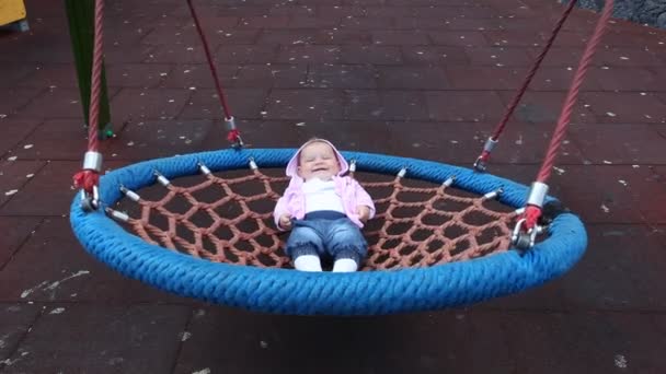 Happy baby girl in a swing — Stock Video