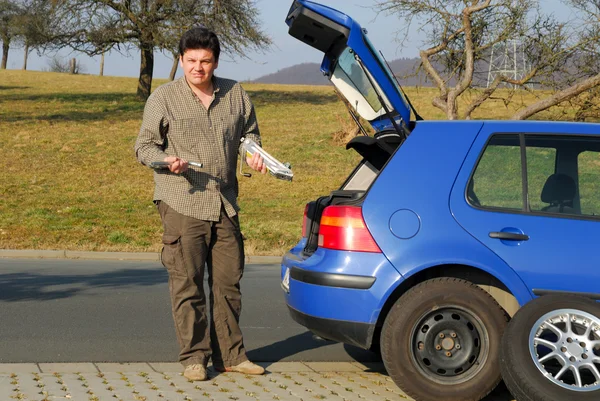 Man changing a tire on the road — Stock Photo, Image