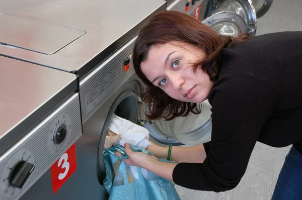 Ung kvinna göra tvätten — Stockfoto