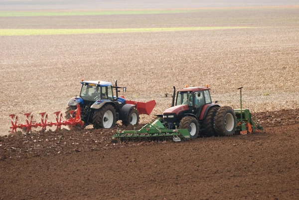 Dva traktory orání pole na podzim — Stock fotografie