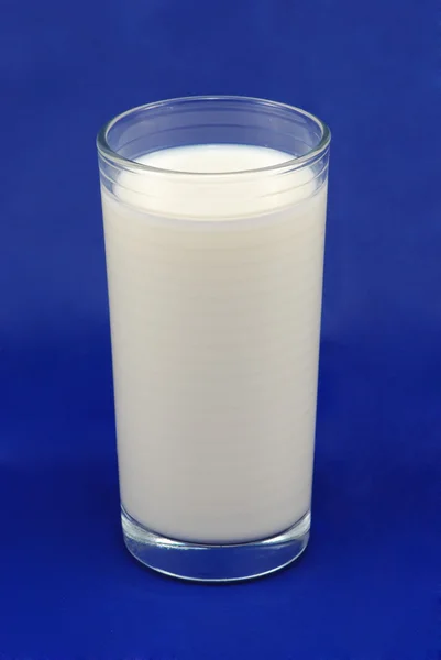 Vaso de leche sobre fondo azul — Foto de Stock