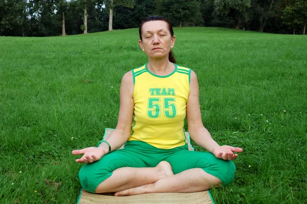 Adatto donna anziana che pratica yoga — Foto Stock