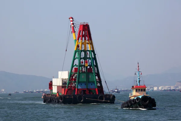 Rebocador com uma barcaça de guindaste no porto de Hong Kong — Fotografia de Stock